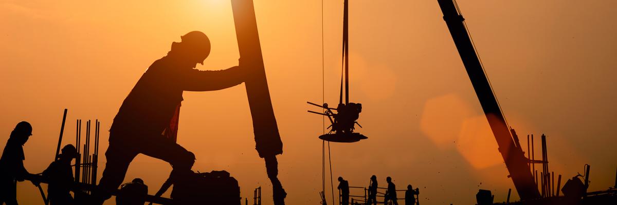 Construction workers pouring concrete into a structure